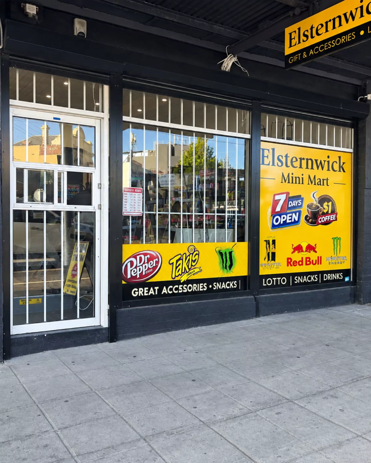 Finished: the mini mart shopfront with a new white aluminium entry door behind security bars