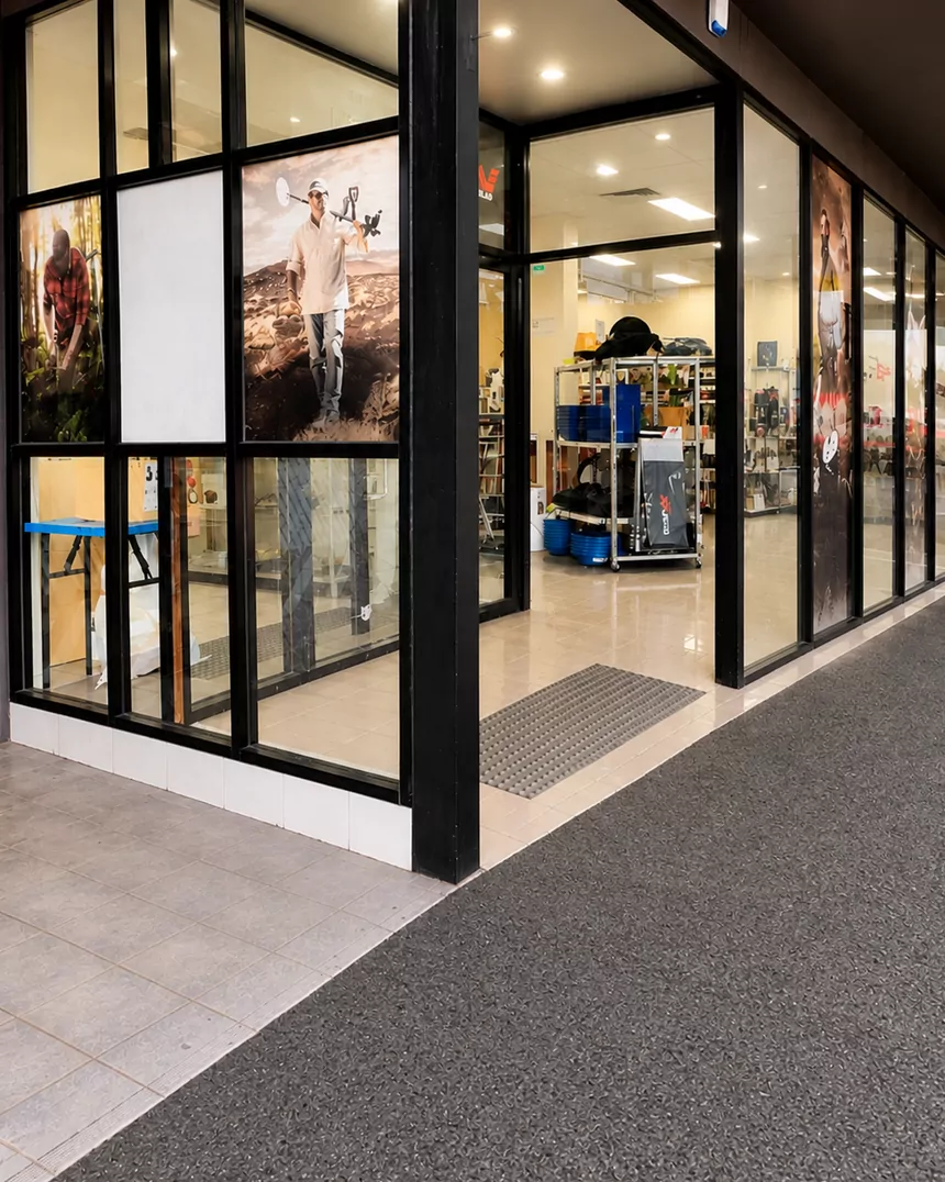 After: the same shop corner with a new black aluminium shopfront and large clear glass panels