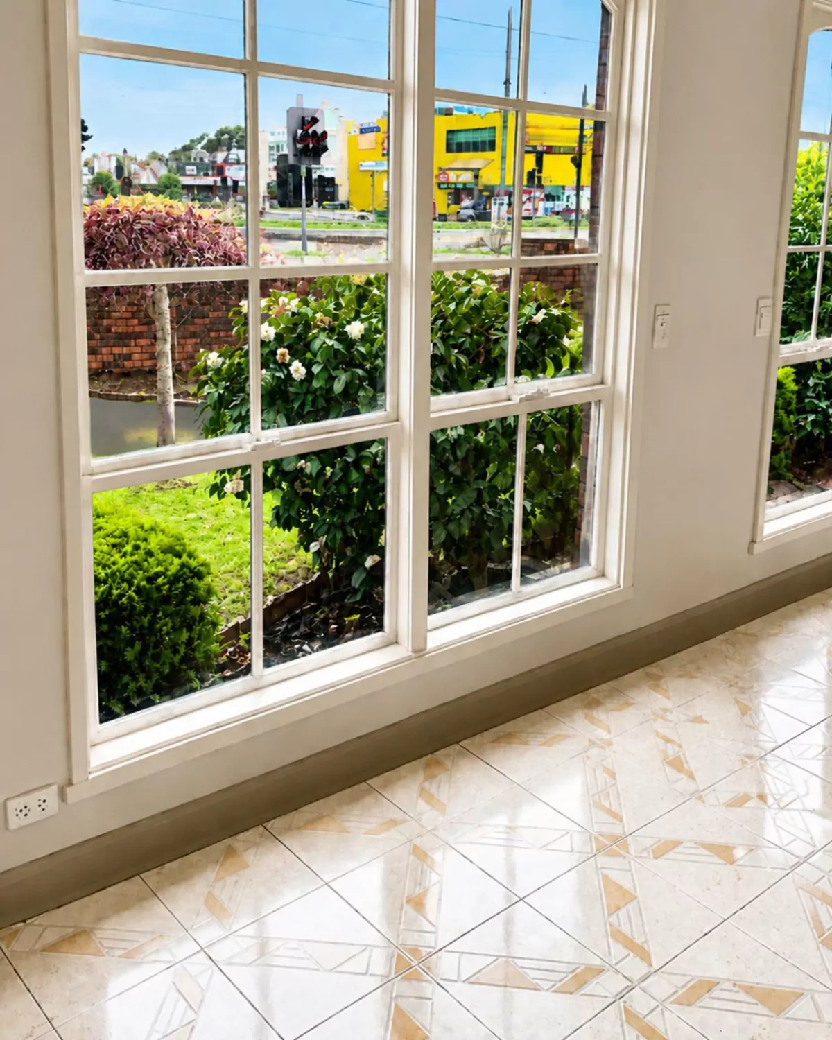 The same timber windows finished: white-painted frames and glazing bars, looking out to the front garden
