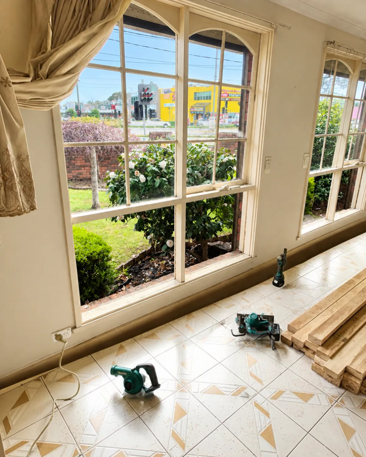 On a Glassy Slide job: arched timber windows mid-repair, with new hardwood lengths and tools on the floor